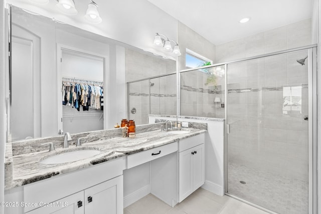 bathroom with tile patterned flooring, vanity, and walk in shower