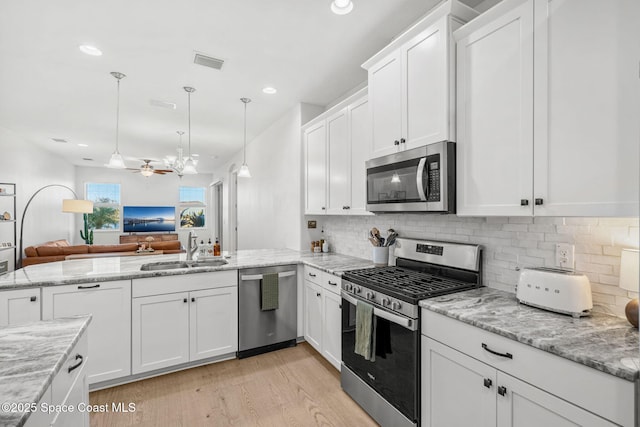 kitchen with white cabinetry, ceiling fan, sink, kitchen peninsula, and appliances with stainless steel finishes