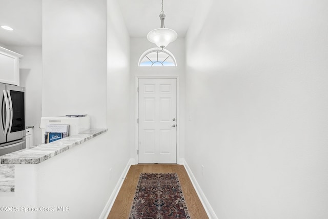 doorway to outside with a high ceiling and dark hardwood / wood-style floors