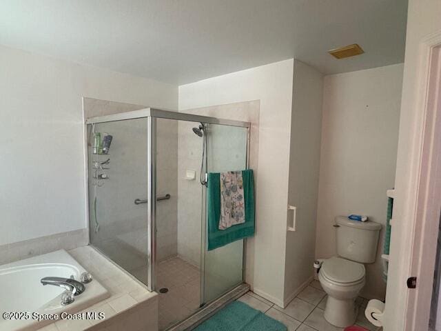 bathroom featuring plus walk in shower, tile patterned floors, and toilet