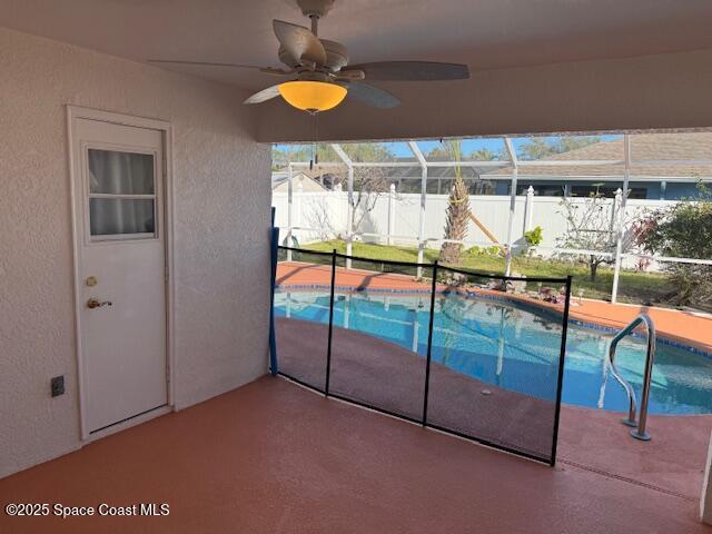 view of swimming pool featuring a patio, a lanai, and ceiling fan