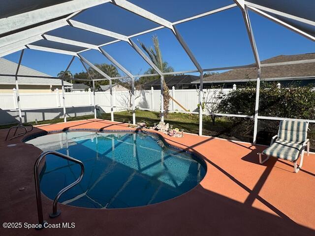 view of pool with a patio and glass enclosure