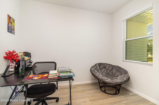 home office with light hardwood / wood-style flooring