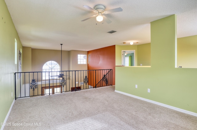 empty room with carpet, ceiling fan, and a textured ceiling