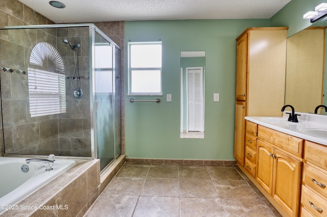 bathroom with vanity, a textured ceiling, and plus walk in shower