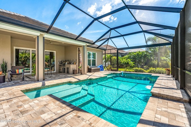 view of swimming pool featuring a patio, ceiling fan, and glass enclosure