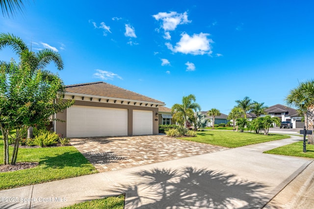 mediterranean / spanish-style house with a garage and a front lawn