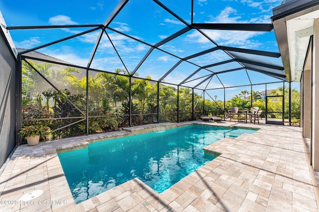 view of swimming pool featuring glass enclosure and a patio