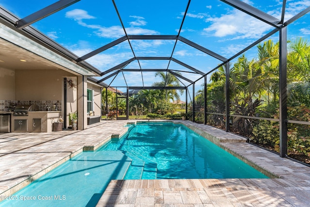 view of pool featuring an outdoor kitchen, a patio, glass enclosure, and a grill