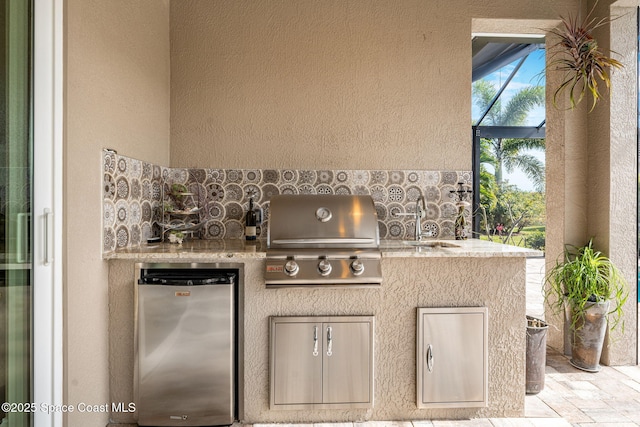 view of patio featuring sink, a grill, and exterior kitchen