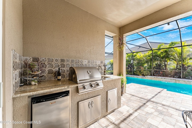 view of patio with an outdoor kitchen and a grill