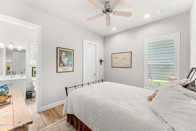 bedroom with ceiling fan, light hardwood / wood-style floors, and connected bathroom