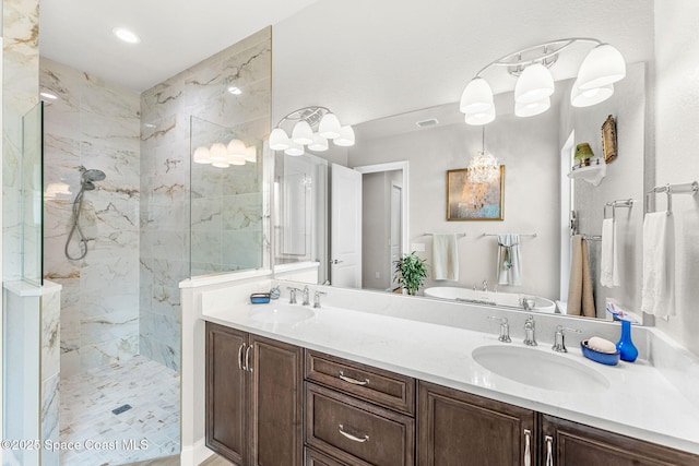 bathroom featuring tiled shower and vanity