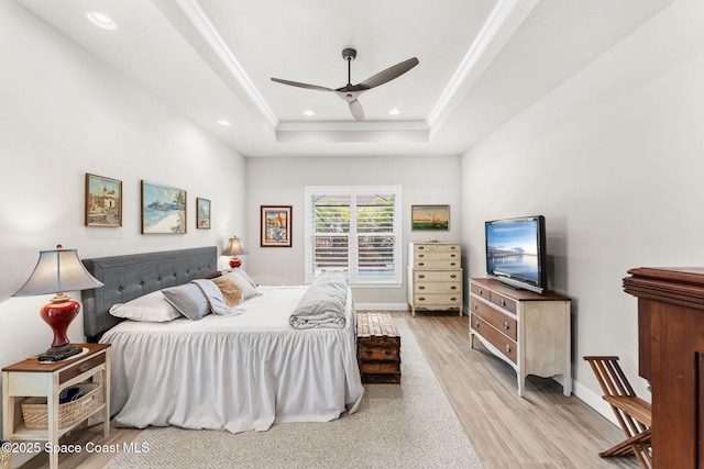 bedroom featuring crown molding, a raised ceiling, ceiling fan, and light hardwood / wood-style flooring