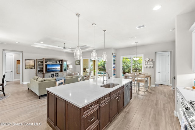 kitchen with sink, decorative light fixtures, a raised ceiling, ceiling fan, and appliances with stainless steel finishes