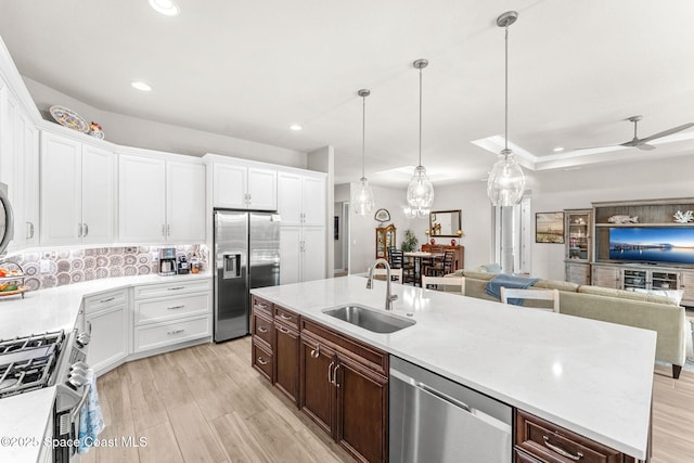 kitchen with stainless steel appliances, white cabinetry, and sink