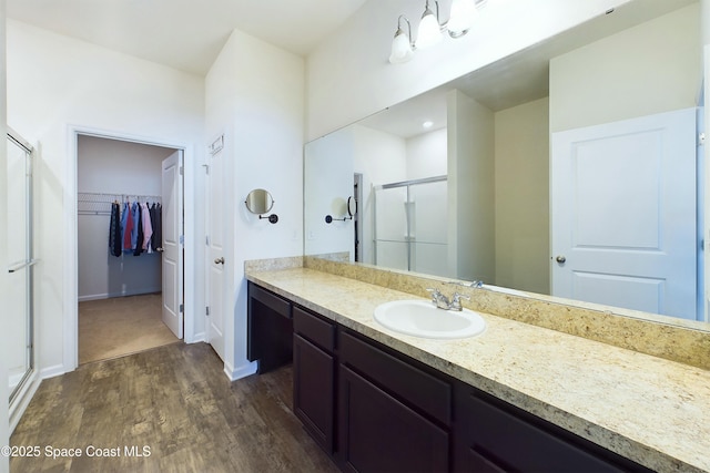 bathroom featuring walk in shower, vanity, and hardwood / wood-style floors