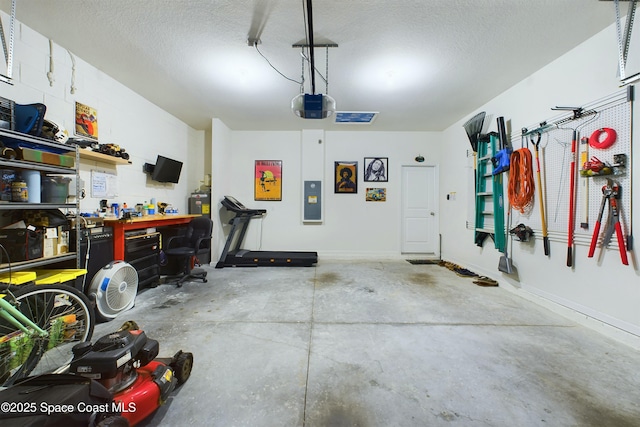 garage featuring a garage door opener, electric panel, and a workshop area