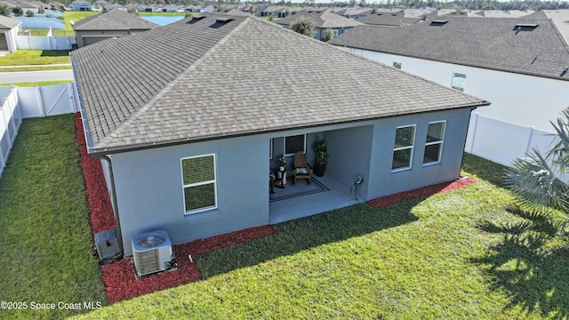 back of house with a patio, a yard, and central air condition unit