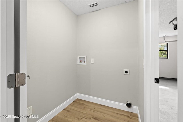 501 Empire Ave NE, Palm Bay, FL 32907 - washroom featuring hookup for a washing machine, a textured ceiling, hardwood / wood-style flooring, and electric dryer hookup