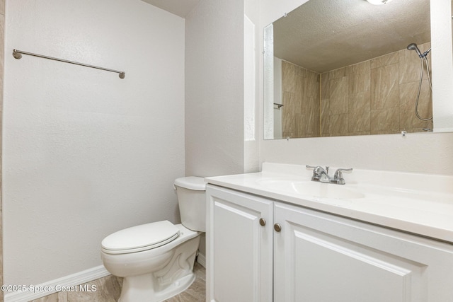 bathroom featuring vanity, toilet, walk in shower, and a textured ceiling