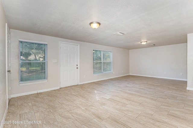 unfurnished room featuring a textured ceiling