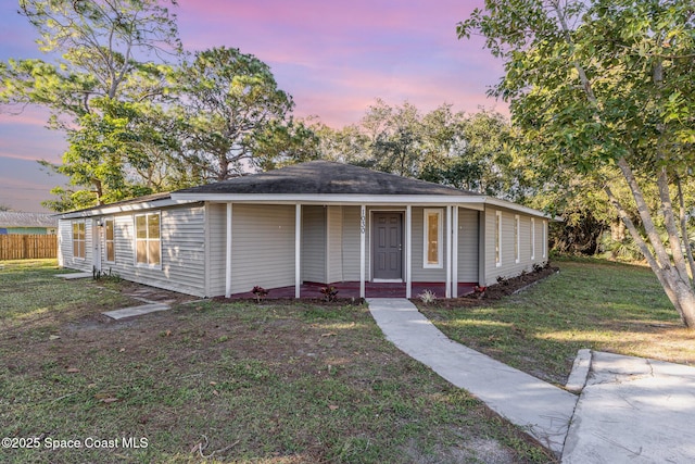 view of front of home with covered porch and a lawn