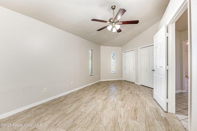 unfurnished bedroom with multiple closets, vaulted ceiling, and ceiling fan