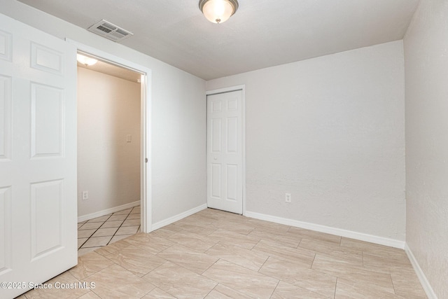 unfurnished bedroom featuring a closet and light tile patterned floors