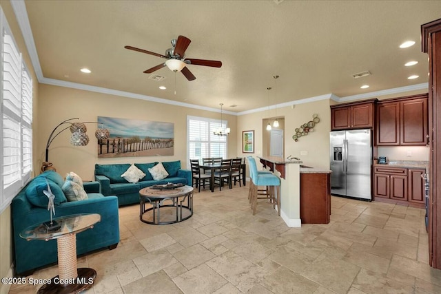 interior space featuring a kitchen breakfast bar, stainless steel refrigerator with ice dispenser, pendant lighting, light stone counters, and a kitchen island with sink