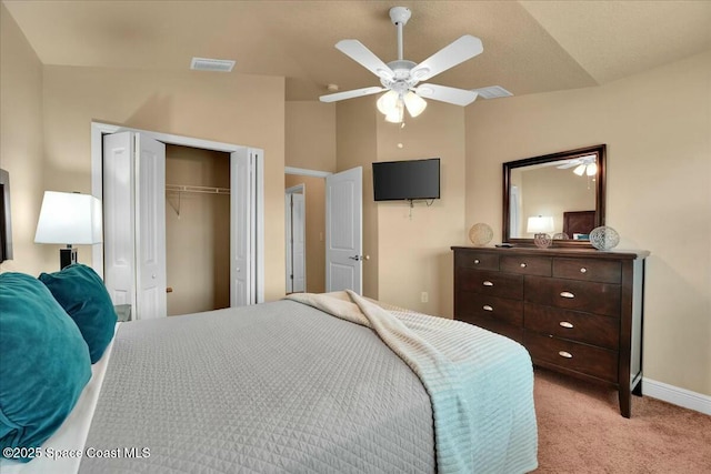 carpeted bedroom with a closet, vaulted ceiling, and ceiling fan