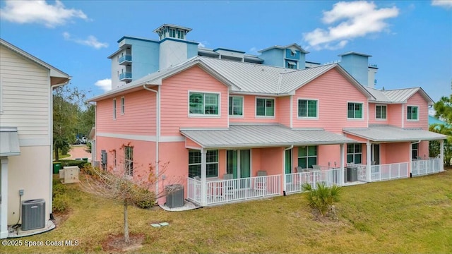 back of property featuring central AC unit and a yard