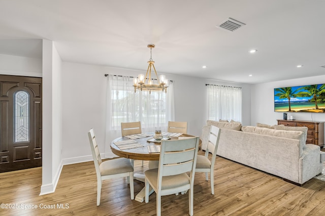 dining space featuring a notable chandelier and light wood-type flooring