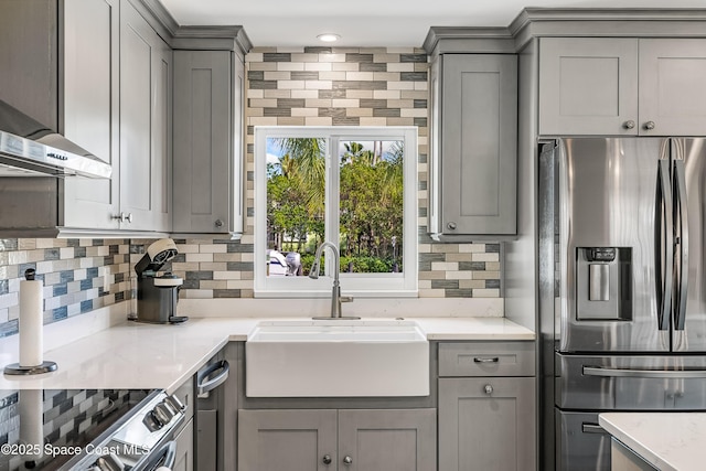 kitchen featuring tasteful backsplash, gray cabinets, sink, and appliances with stainless steel finishes