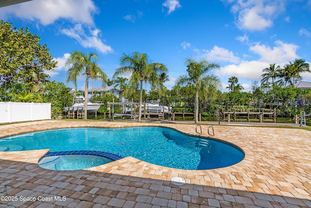 view of swimming pool featuring an in ground hot tub and a boat dock