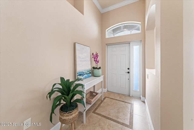 tiled foyer entrance featuring a high ceiling and ornamental molding