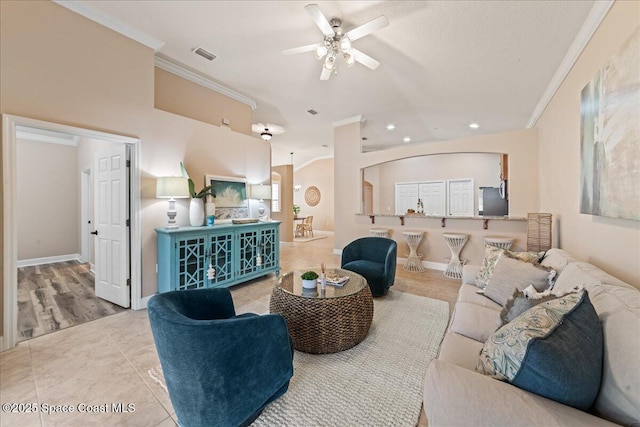 living room with ceiling fan, light tile patterned floors, and crown molding