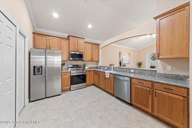 kitchen with stainless steel appliances, crown molding, light stone counters, sink, and lofted ceiling