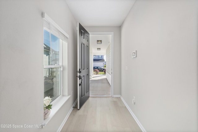 corridor with light hardwood / wood-style floors