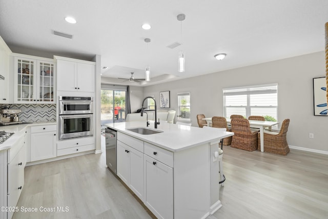 kitchen featuring white cabinets, decorative light fixtures, ceiling fan, and sink