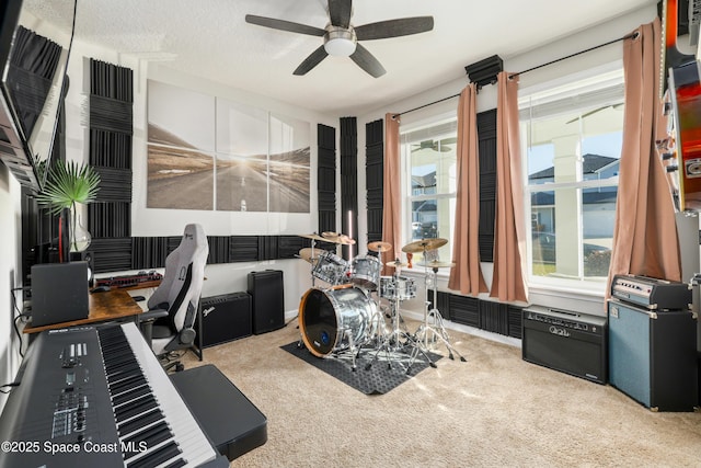 misc room with a textured ceiling, light colored carpet, and ceiling fan