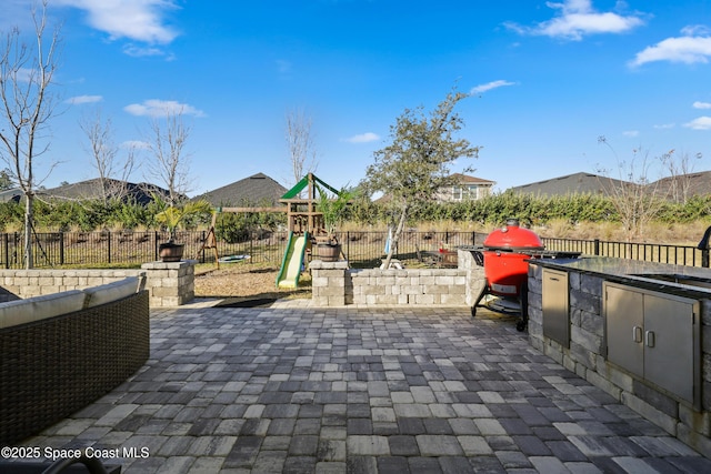 exterior space with an outdoor kitchen and a playground