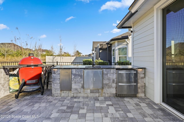 view of patio with an outdoor kitchen and a grill