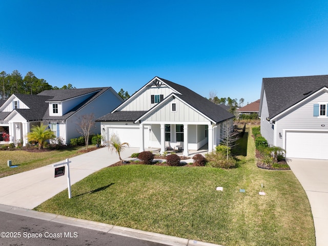 modern farmhouse featuring a garage, covered porch, and a front lawn