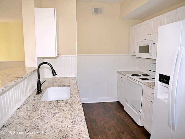 kitchen with white cabinetry, sink, light stone countertops, and white appliances