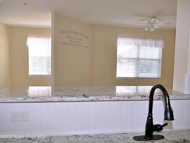 interior space featuring light stone countertops and ceiling fan