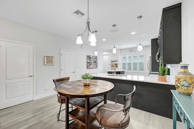 dining space with sink and light hardwood / wood-style floors