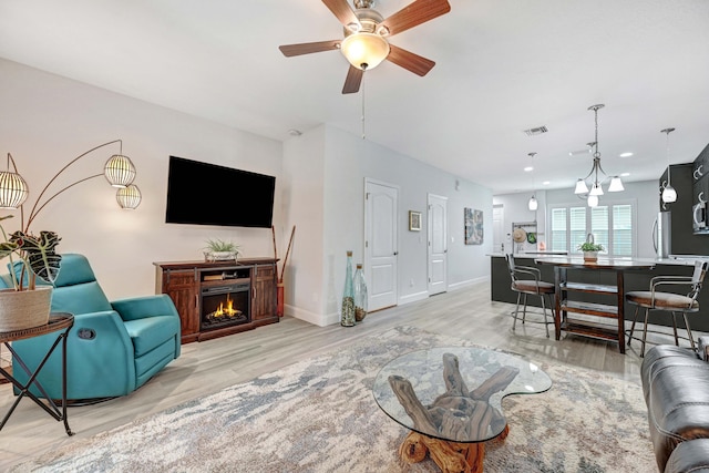 living room featuring light wood-type flooring and ceiling fan