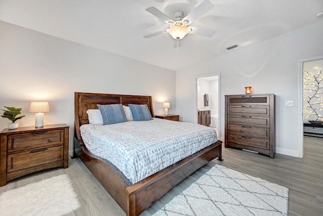 bedroom with ceiling fan, light wood-type flooring, and connected bathroom