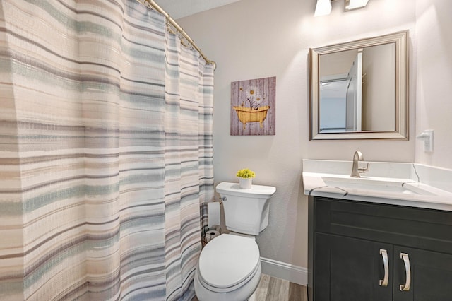 bathroom featuring toilet, vanity, hardwood / wood-style flooring, and walk in shower